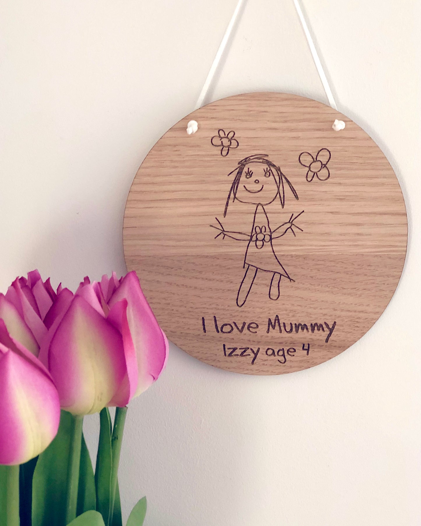 children's drawing engraved into a circular wooden plaque