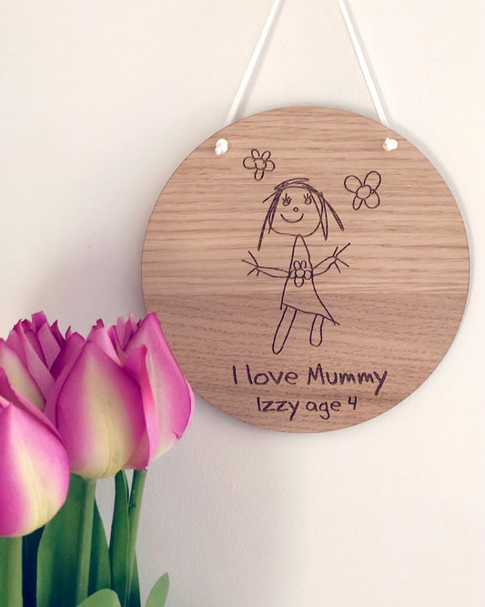 children's drawing engraved into a circular wooden plaque