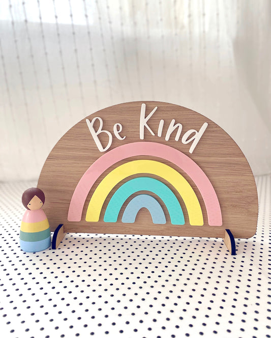Wooden freestanding rainbow with pastel acrylic and the words Be Kind