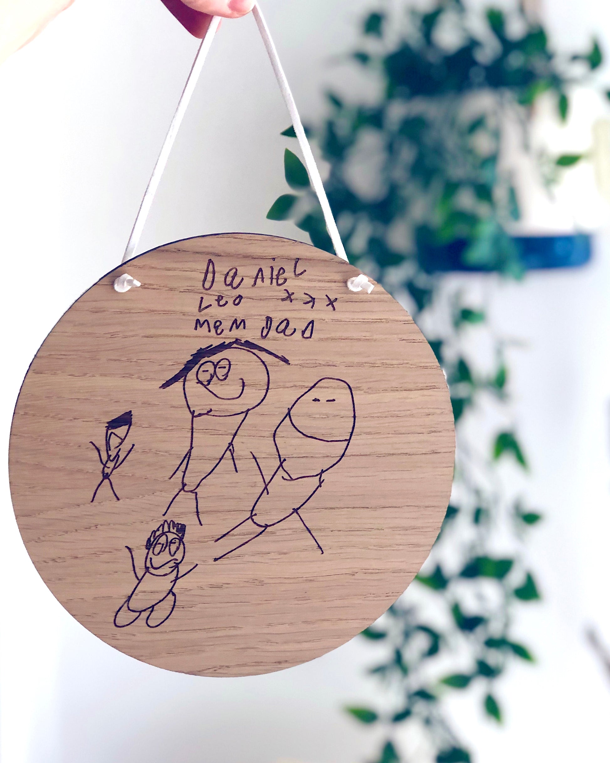 children's drawing engraved into a circular wooden plaque