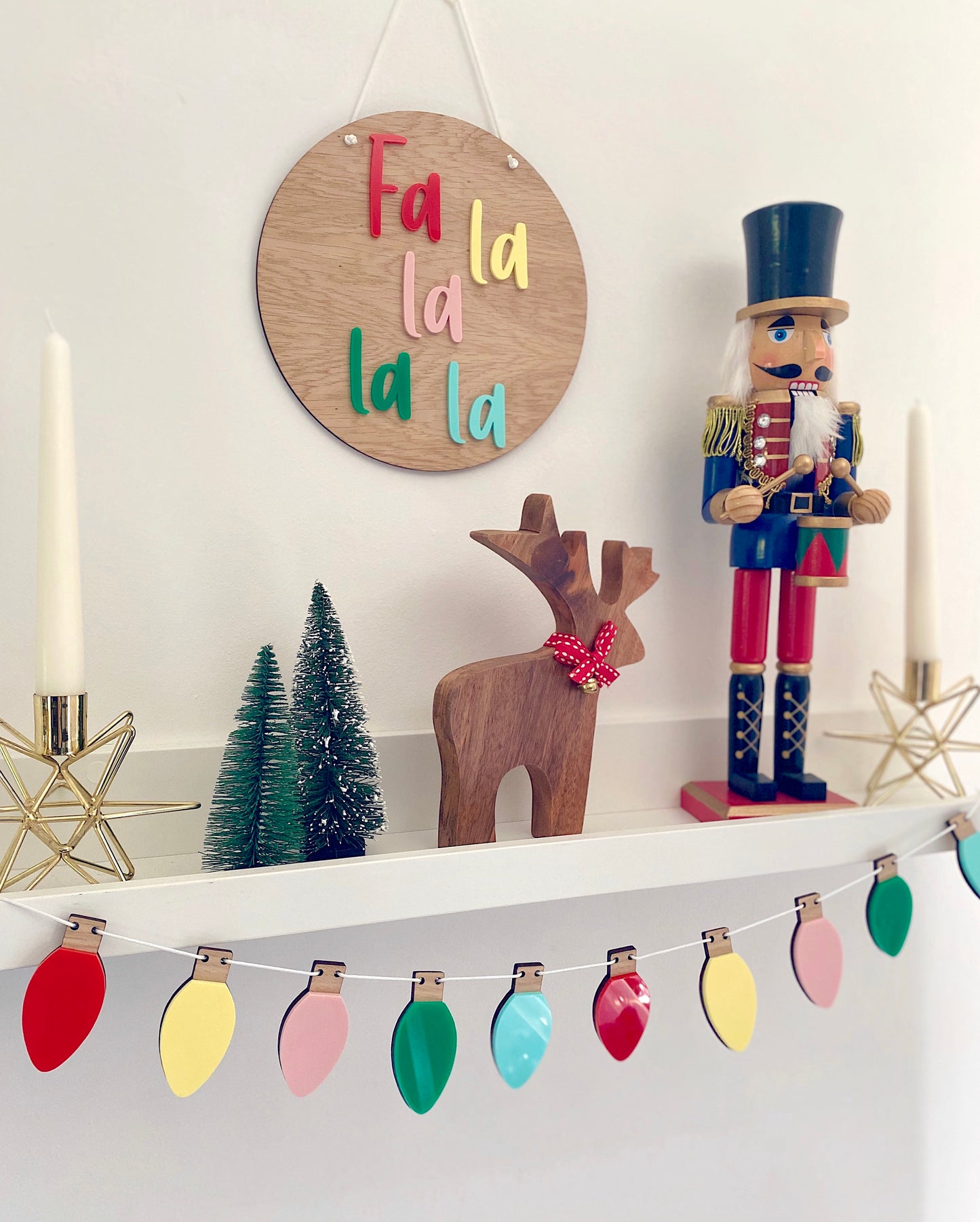 Shelf filled with christmas decorations including colour plaque and christmas lights garland