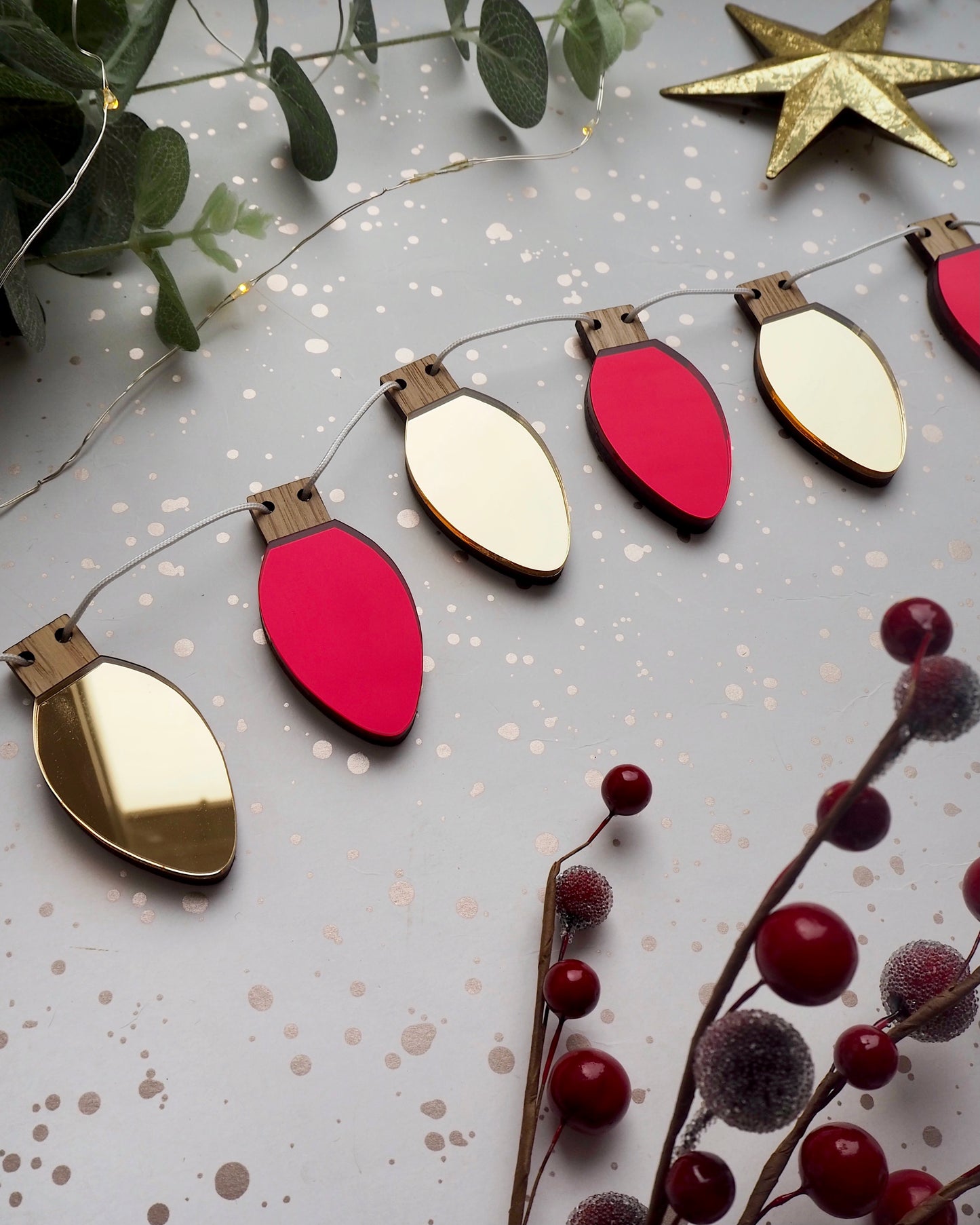 Metallic red and gold Christmas garland in the shape of fairy lights