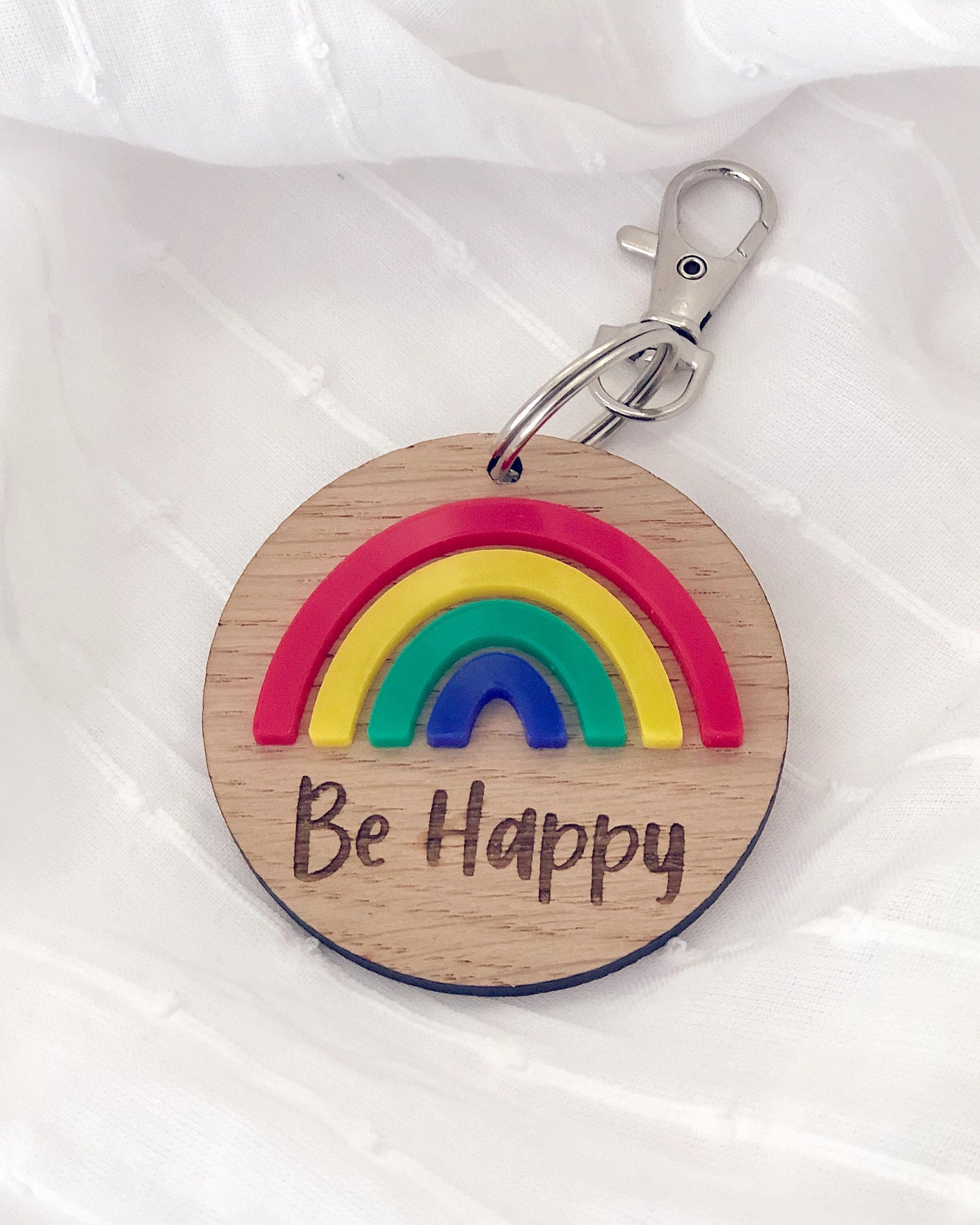 Wooden key ring with colourful rainbow and be happy engraved text