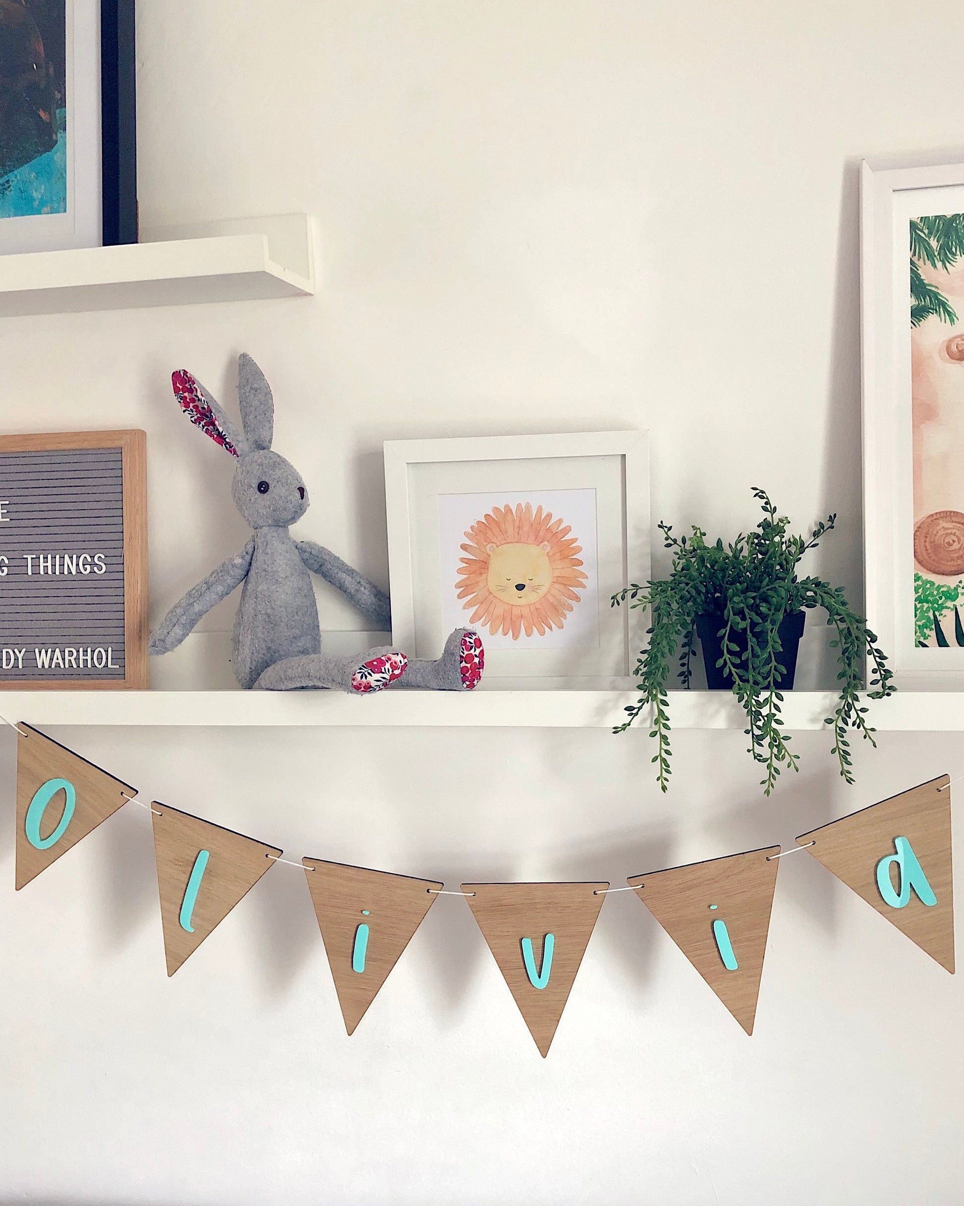 Wooden name bunting hanging under a shelf