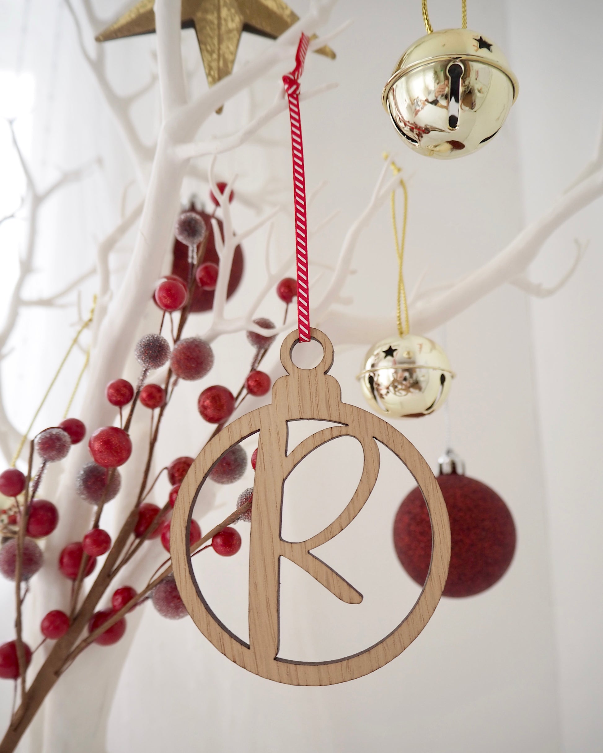 wooden Christmas bauble with the letter R laser cut from the middle