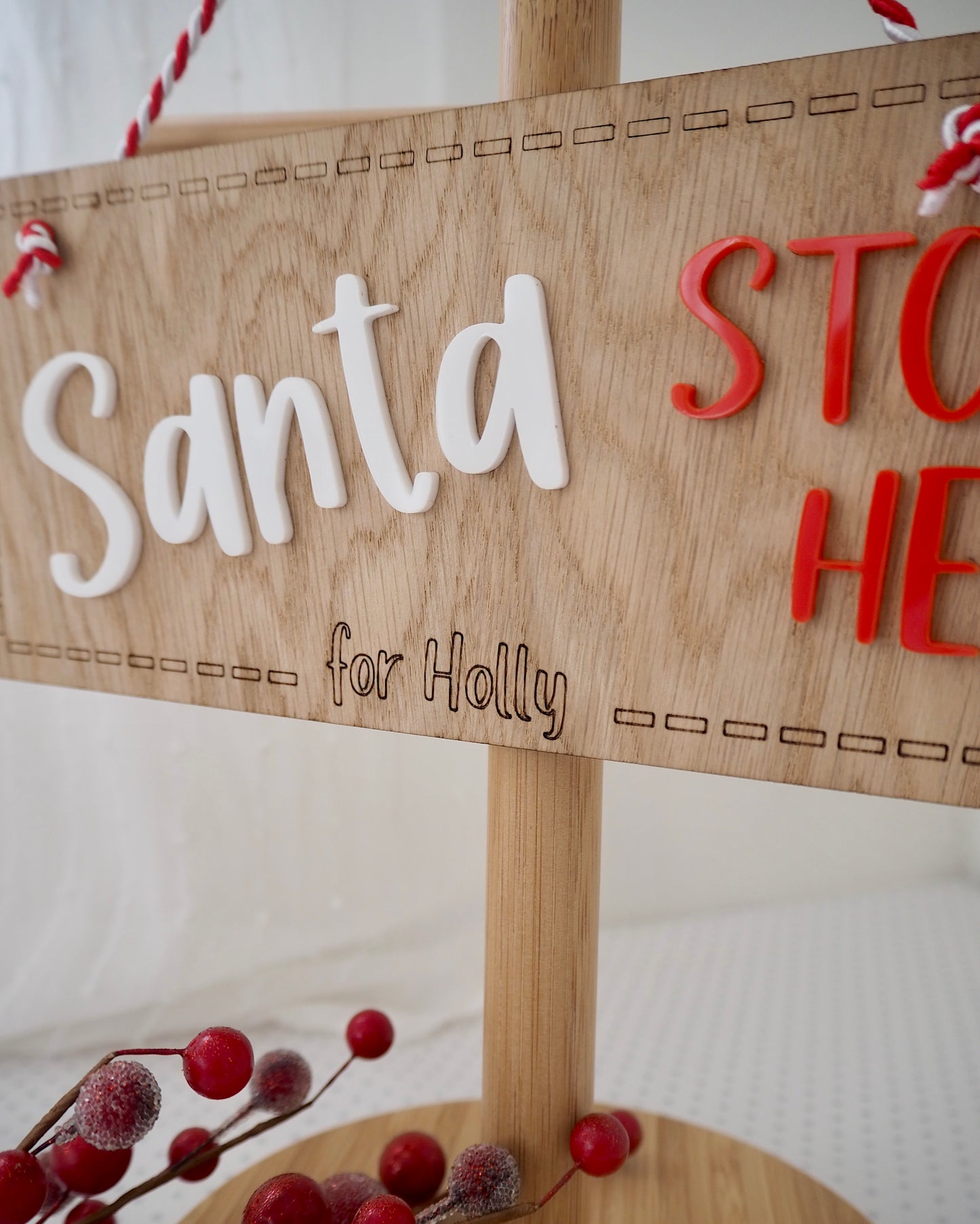 Close up of personalisation on a wooden santa stop here sign