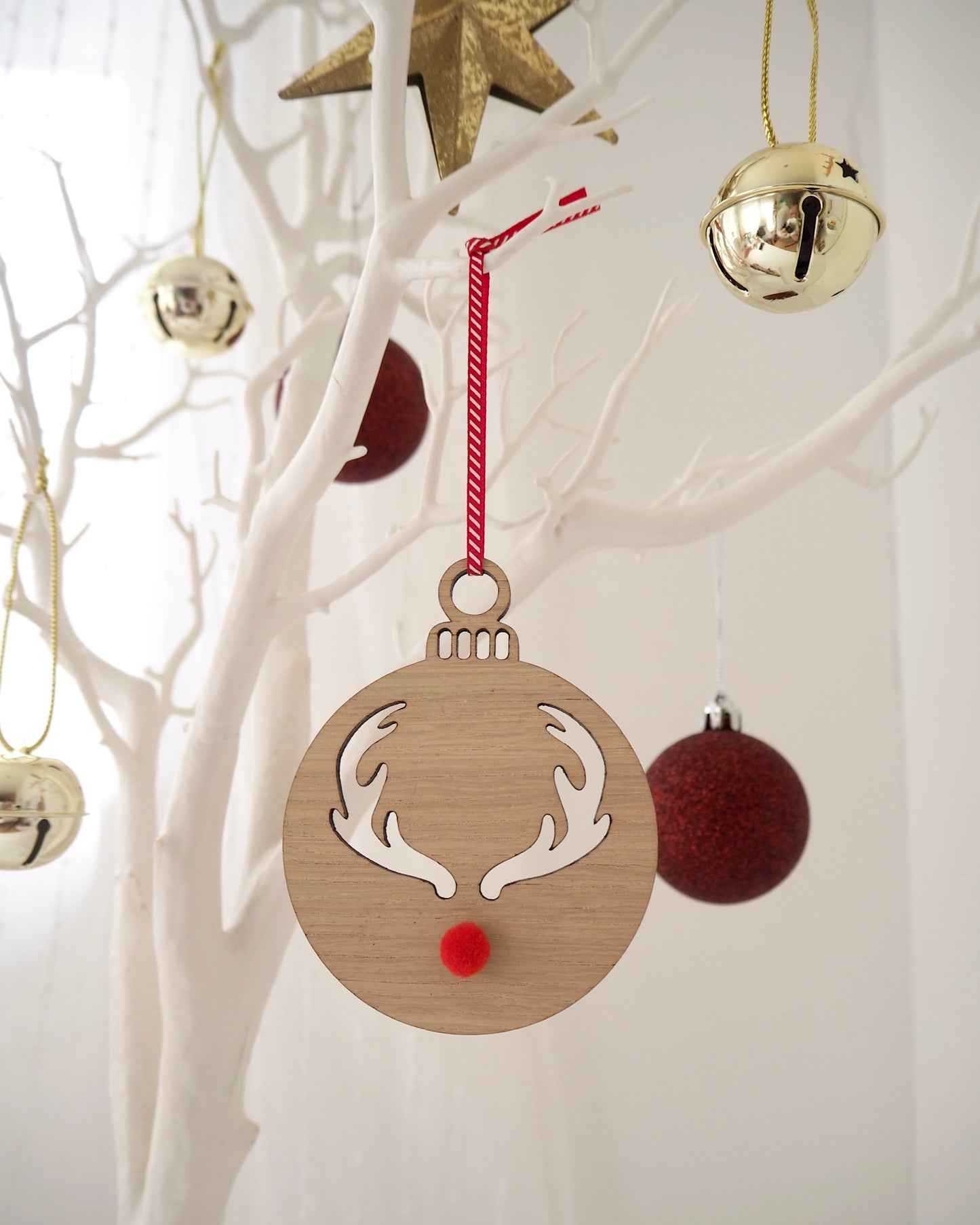 Wooden Christmas bauble with reindeer antlers laser cut out and a red pom pom nose