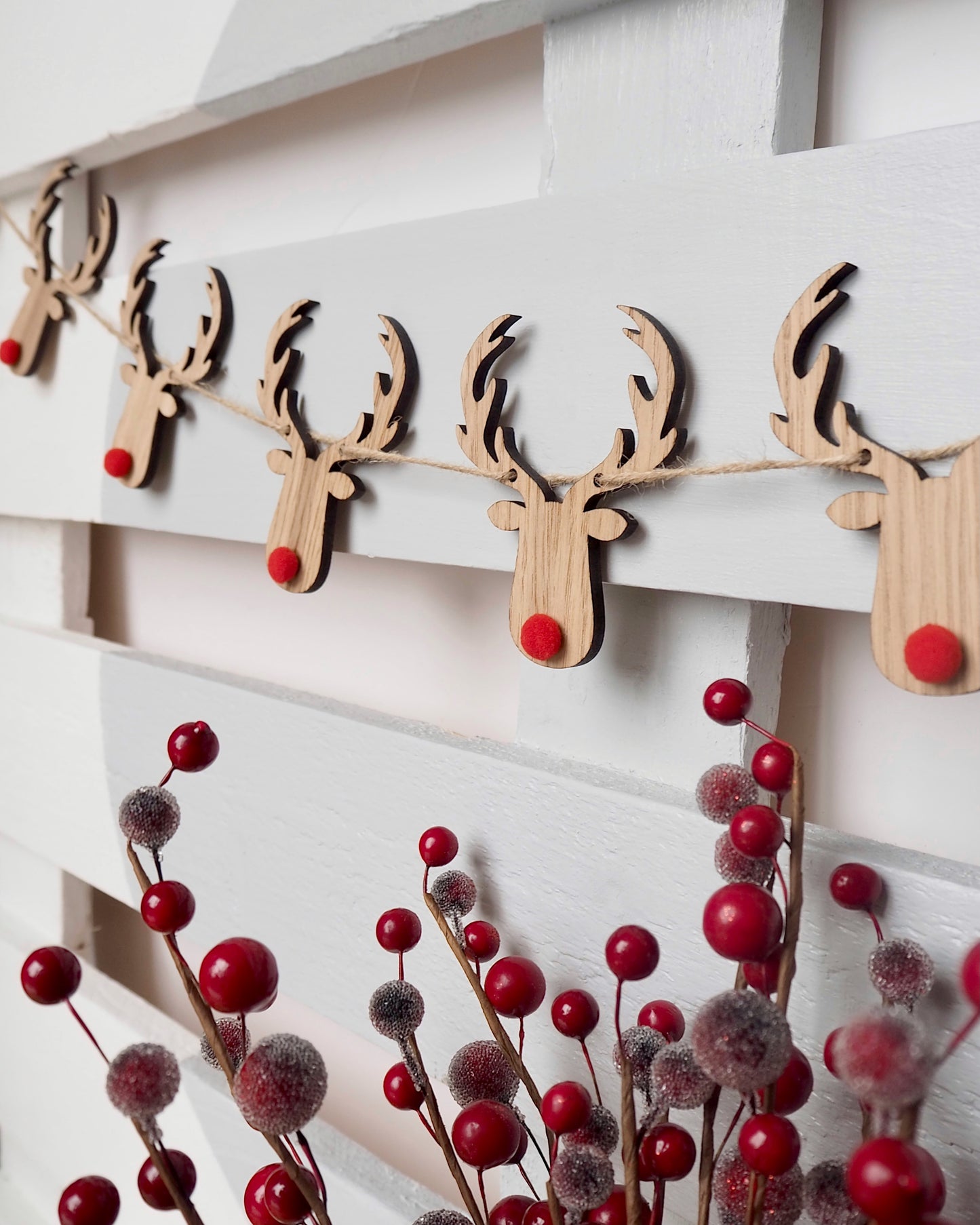 wooden reindeers with red pom pom noses on a jute string garland