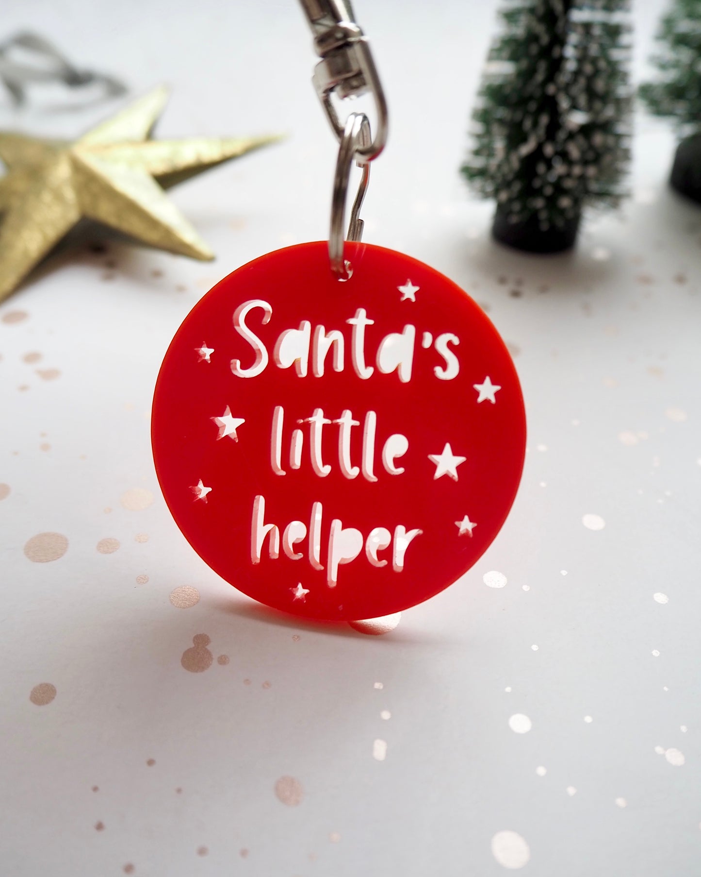 Red acrylic key ring with the words Santa's little helper cut out