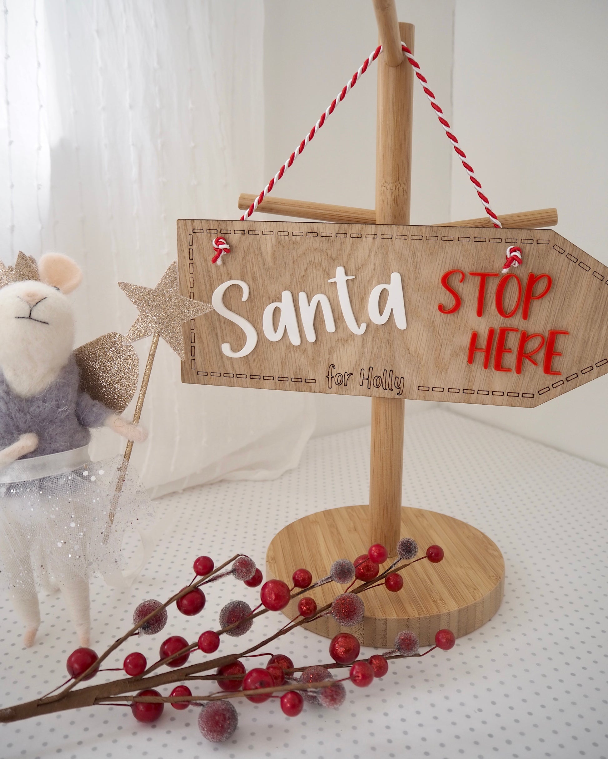 Wooden sign with santa stop her in red and white acrylic letters and a name engraved for personalisation