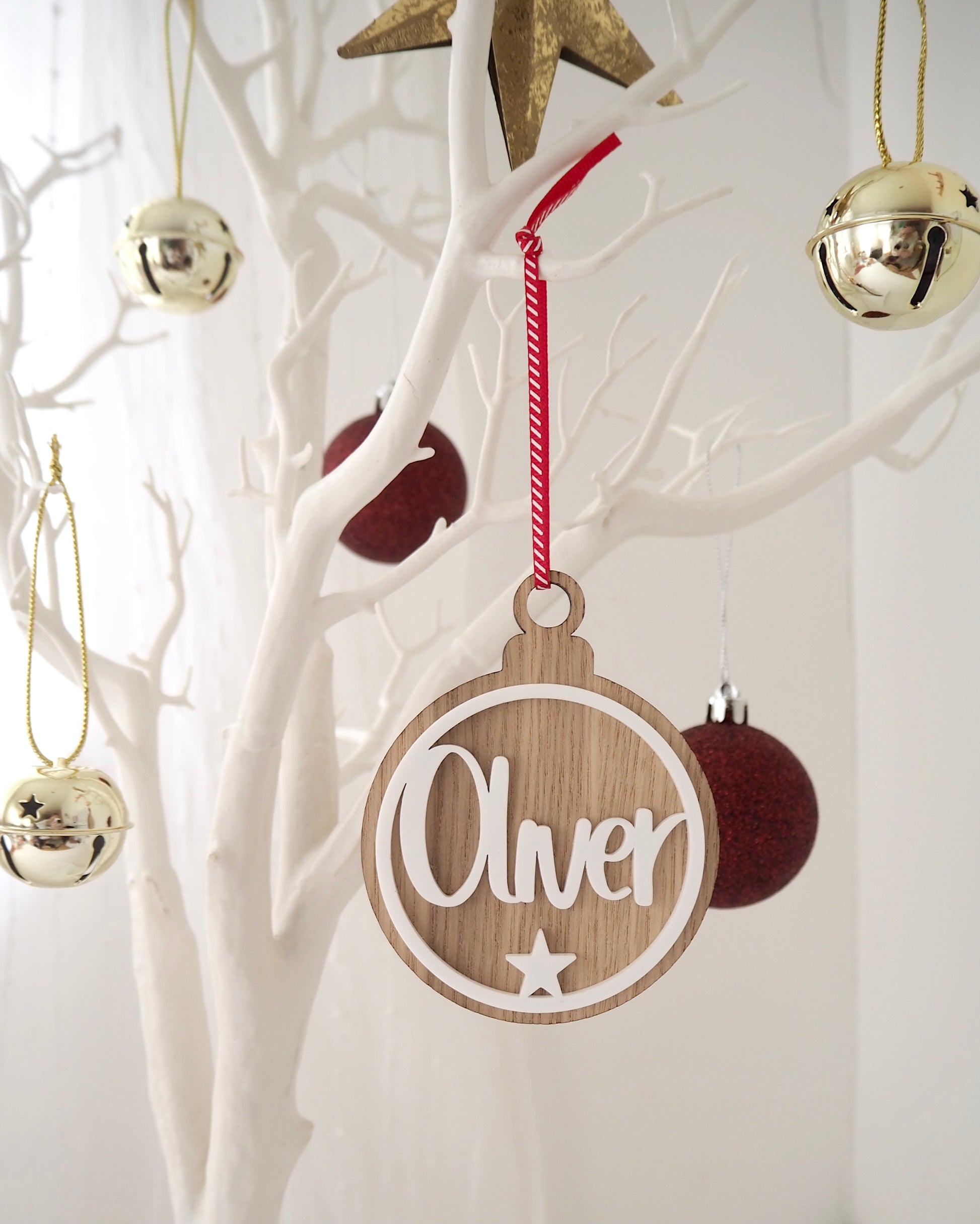 Wooden Christmas bauble with name and star on the front cut from white acrylic